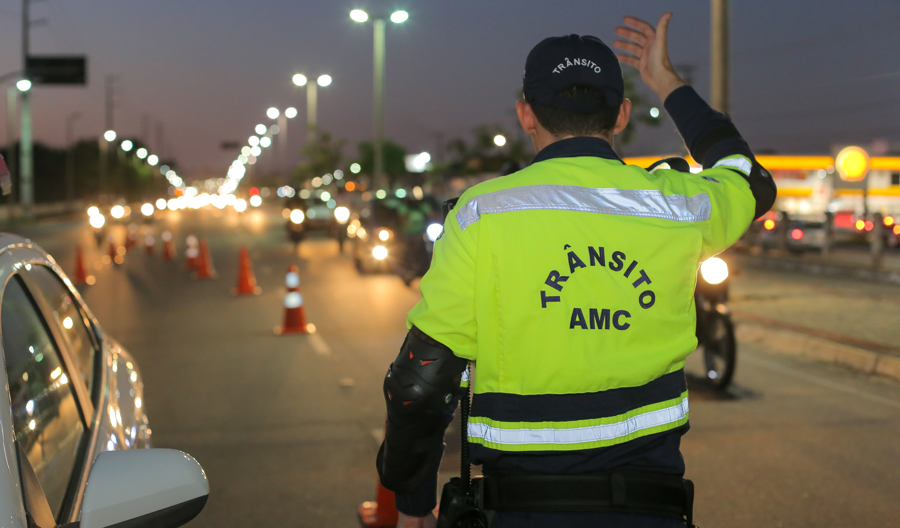 agente da amc de costas orienta o trânsito